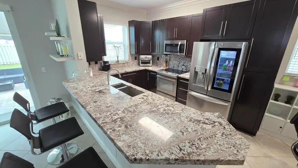 a kitchen with stainless steel appliances granite countertop a sink stove and refrigerator