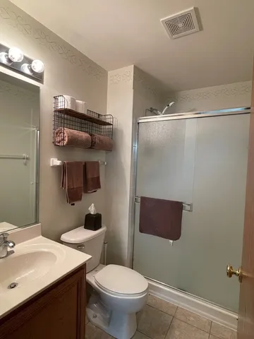 a bathroom with a sink a toilet a mirror and shower