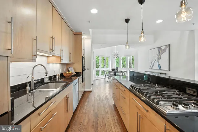 a kitchen with stainless steel appliances kitchen island granite countertop a stove and a refrigerator
