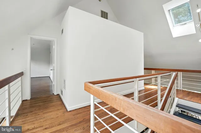 a view of an empty room with wooden floor and closet