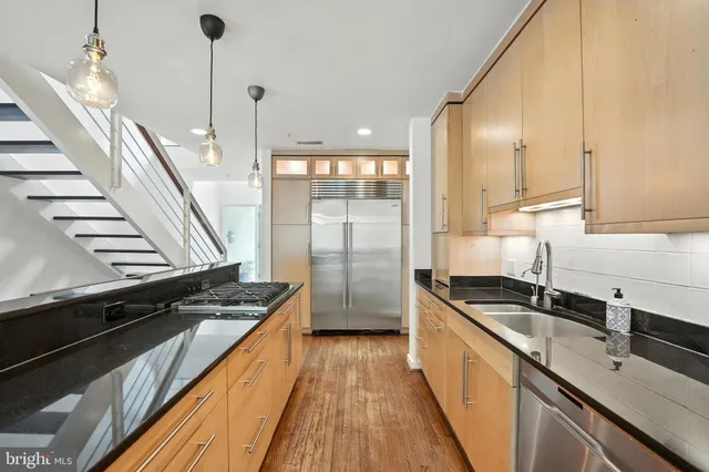 a dining room with wooden floor a chandelier a wooden table and chairs
