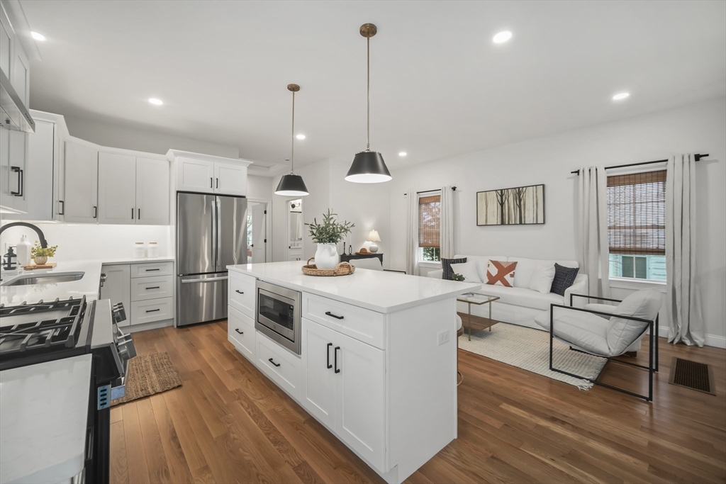 16 Clinton Street Marlborough, MA 01752 - Photo 12 of 39 a kitchen with stainless steel appliances granite countertop a stove top oven a refrigerator a sink and white cabinets with wooden floor