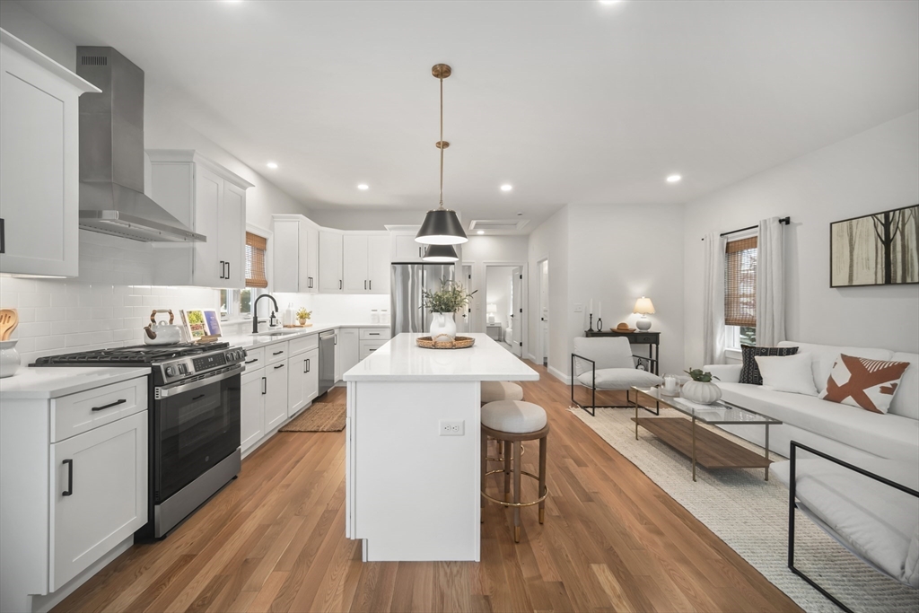 16 Clinton Street Marlborough, MA 01752 - Photo 7 of 39 a open kitchen with stainless steel appliances kitchen island a stove a sink dishwasher and a dining table with wooden floor