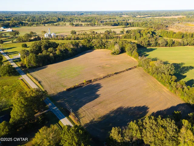 an aerial view of ocean and residential houses with outdoor space