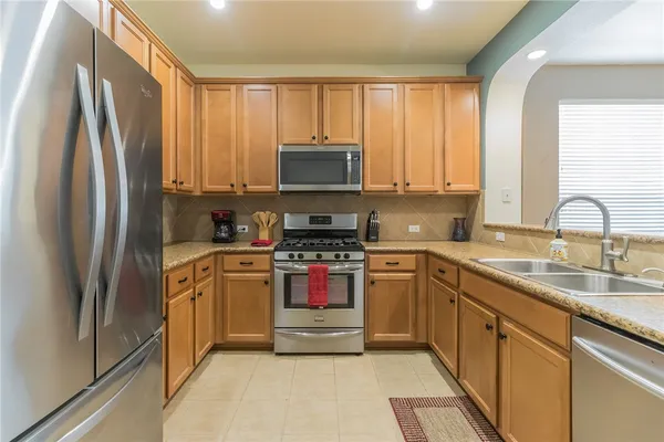 a kitchen with stainless steel appliances granite countertop a refrigerator stove and sink