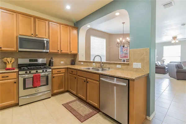 a kitchen with stainless steel appliances granite countertop a stove sink and microwave