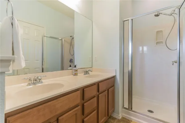 a bathroom with a shower sink vanity and mirror