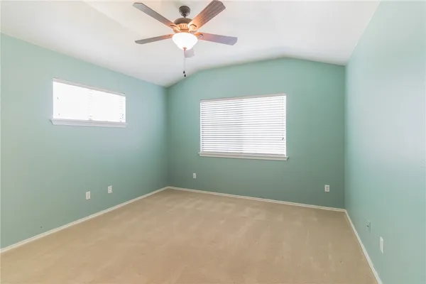 an empty room with a window and ceiling fan