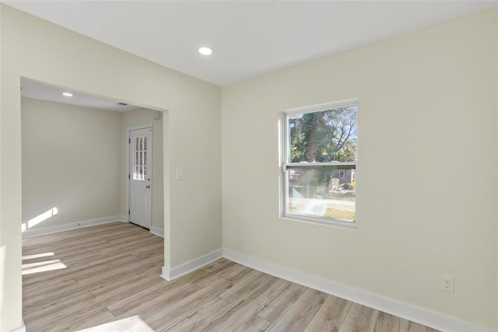 5476 Old Rockbridge Road Stone Mountain, GA 30083 - Photo 14 of 35 an empty room with wooden floor and windows