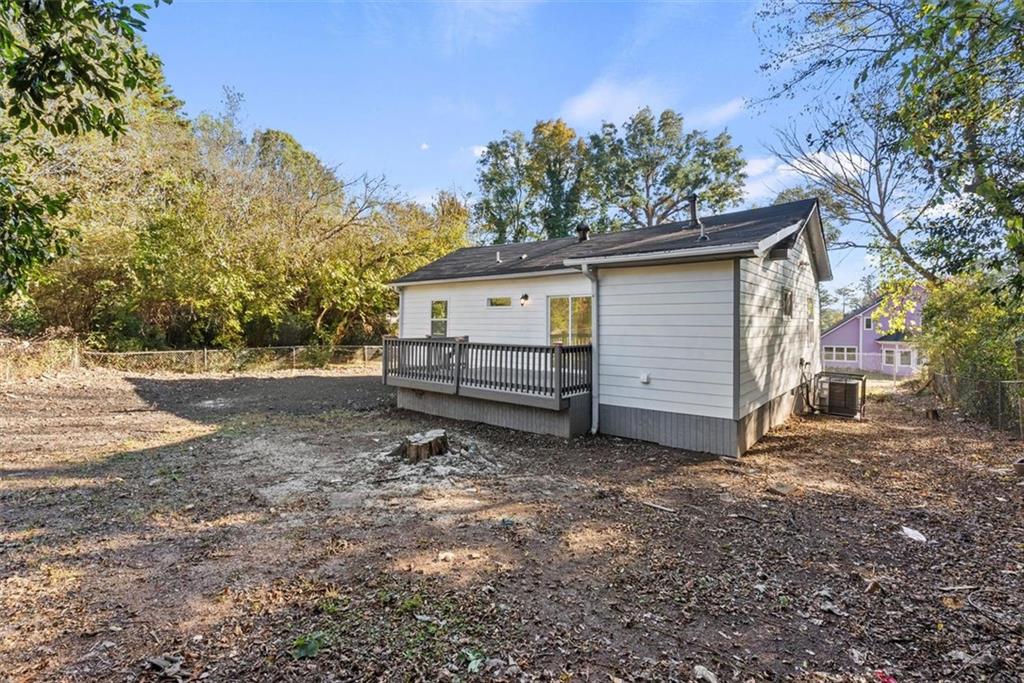 5476 Old Rockbridge Road Stone Mountain, GA 30083 - Photo 27 of 35 a view of backyard of house with wooden fence and trees