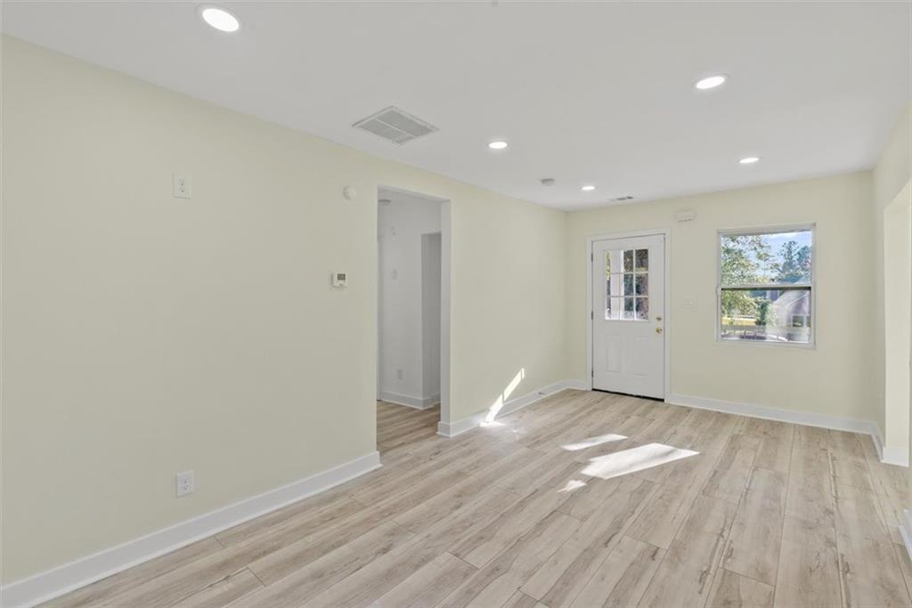 5476 Old Rockbridge Road Stone Mountain, GA 30083 - Photo 4 of 35 an empty room with wooden floor and windows