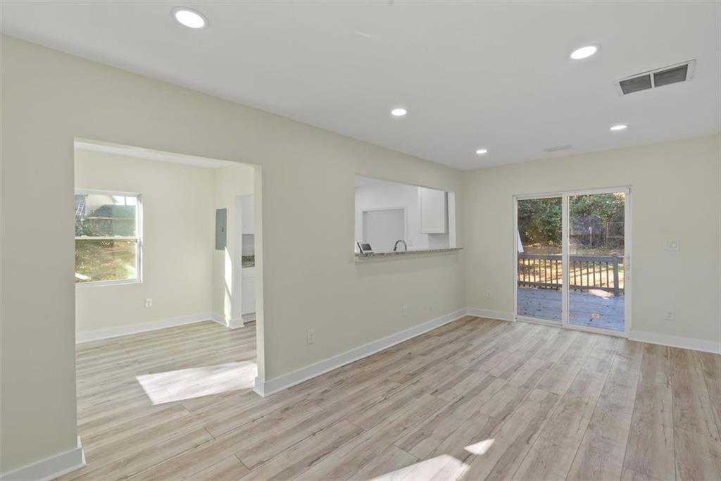 5476 Old Rockbridge Road Stone Mountain, GA 30083 - Photo 5 of 35 wooden floor in an empty room with a window