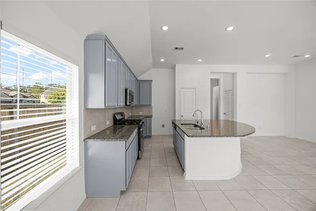 a kitchen with stainless steel appliances granite countertop a sink and a stove