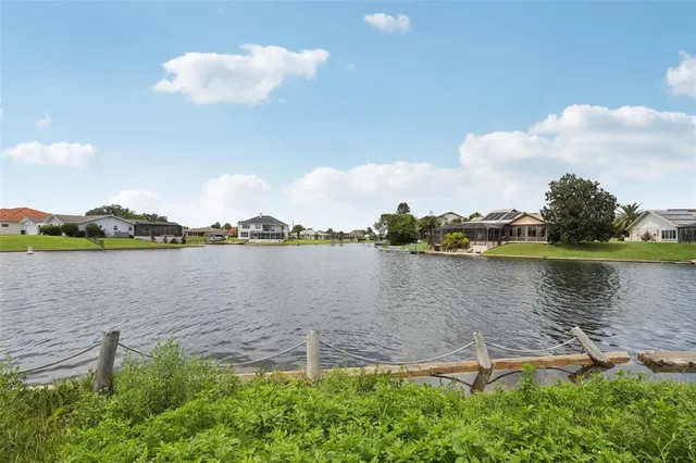 a view of a house with a yard and palm trees