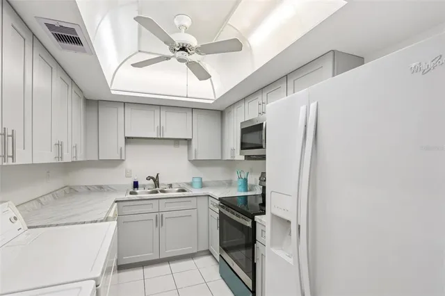 a kitchen with a sink stainless steel appliances and white cabinets