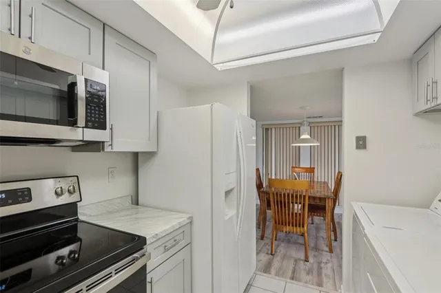a kitchen with stainless steel appliances a stove a microwave and white cabinets