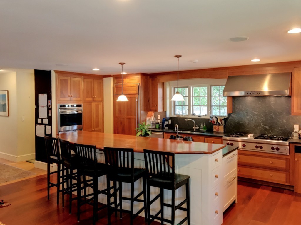 44 Stevens Road Needham, MA 02492 - Photo 4 of 14 a kitchen with stainless steel appliances granite countertop a stove a sink a microwave dining table and chairs