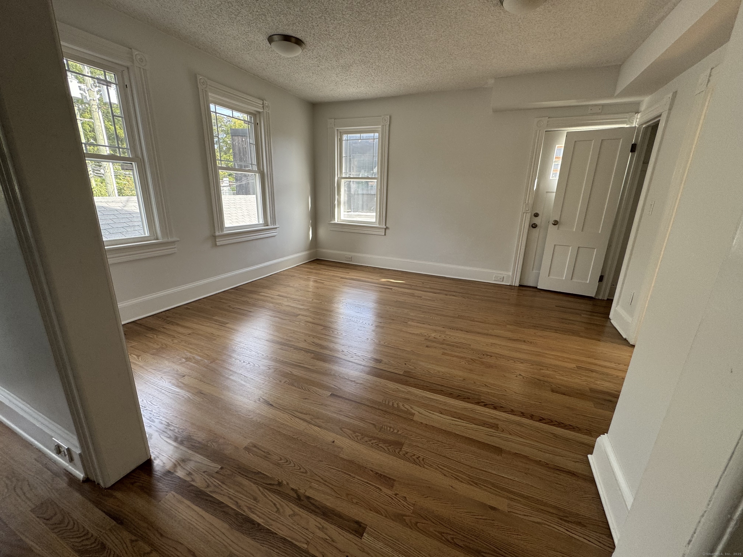 66 Church Lane Westport, CT 06880 - Photo 8 of 22 an empty room with wooden floor and windows