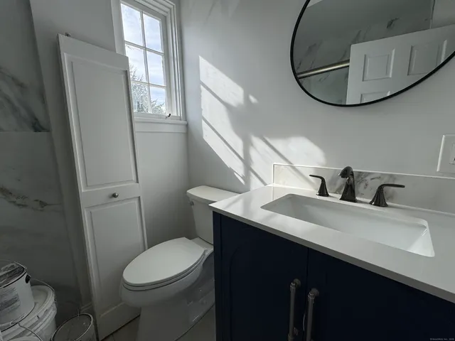 a bathroom with a sink a toilet and mirror