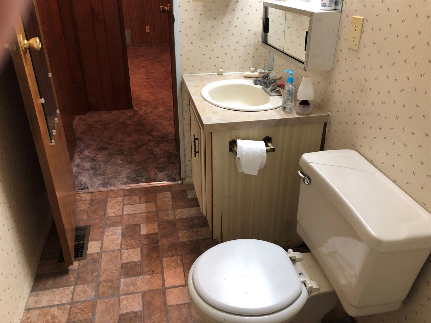 6226 East Evans Creek Road, Unit 15 Rogue River, OR 97537 - Photo 23 of 30 a bathroom with a sink a toilet and a mirror