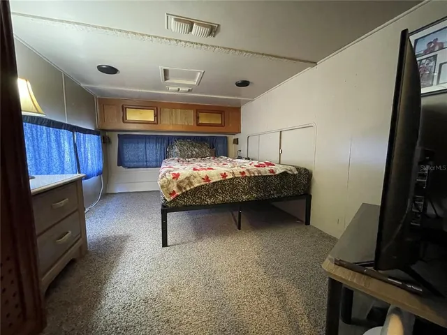 a bedroom with a bed and a mirror on the wall