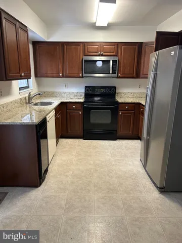 a kitchen with a refrigerator sink and cabinets