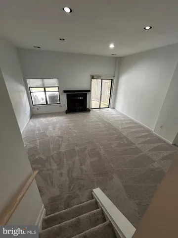 a view of empty room with wooden floor and windows