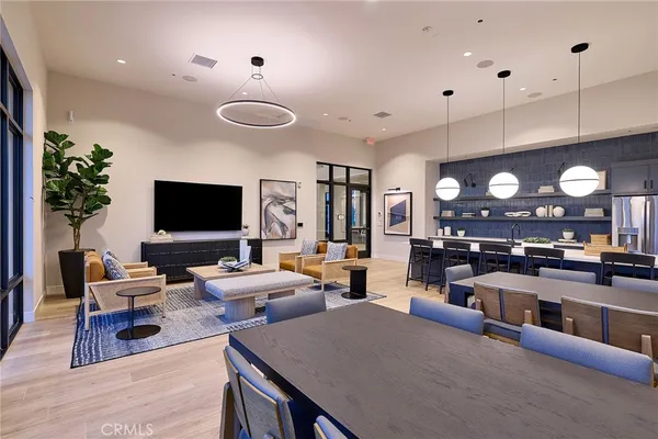 a living room with furniture a flat screen tv and kitchen view