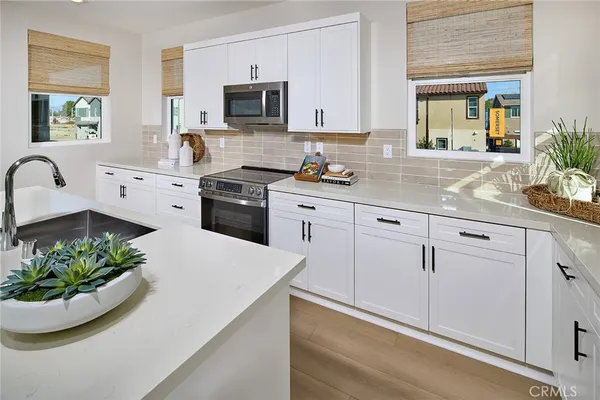 a kitchen with kitchen island granite countertop white cabinets and window