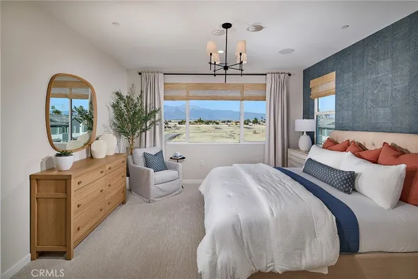 a bedroom with a large bed and a chandelier