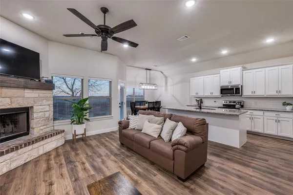 a living room with furniture a flat screen tv and a fireplace