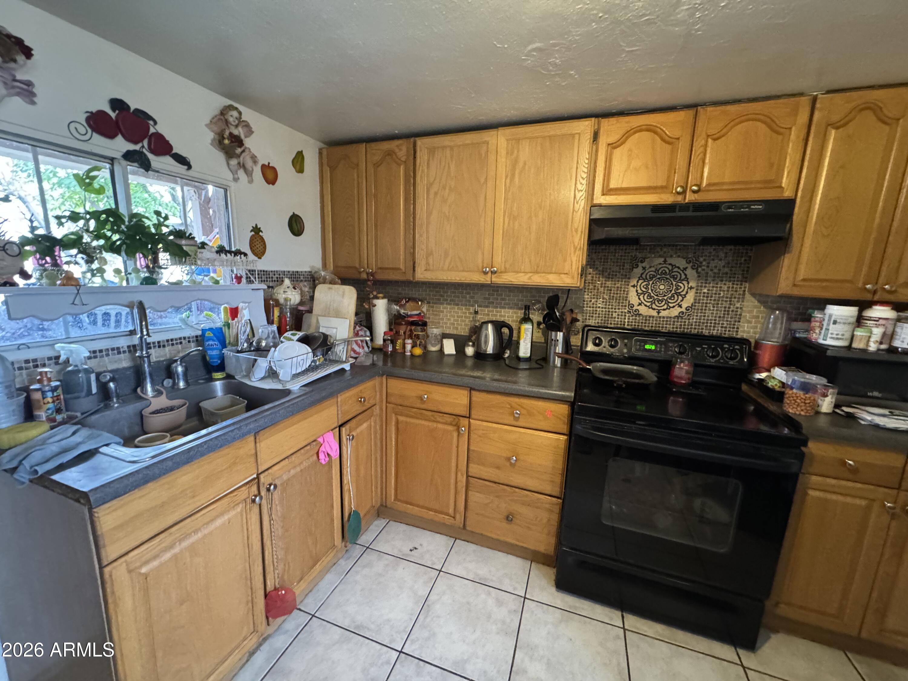 740 West Cinnabar Avenue Phoenix, AZ 85021 - Photo 18 of 26 a kitchen with stainless steel appliances granite countertop a sink stove and cabinets