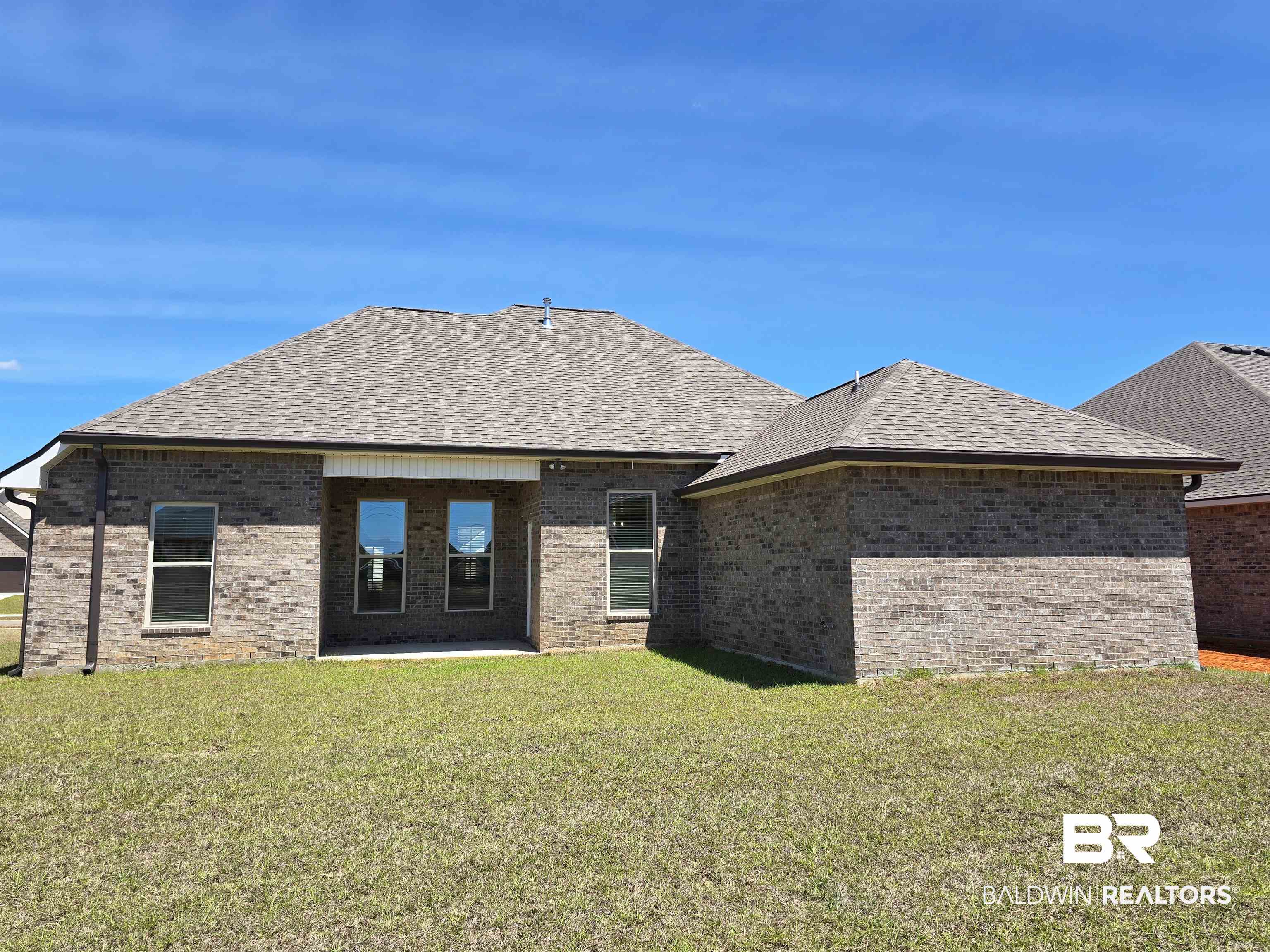 11178 Bonaventure Avenue Daphne, AL 36526 - Photo 18 of 20 Rear view of house with roof with shingles, a patio area, brick siding, and a lawn