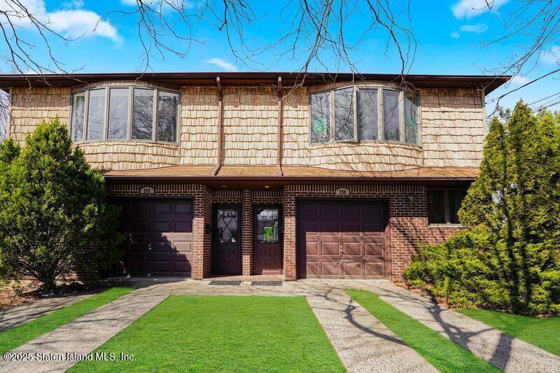 a front view of a house with a garden and yard