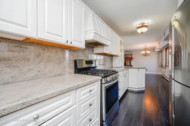 a kitchen with stainless steel appliances granite countertop a stove a sink and a refrigerator