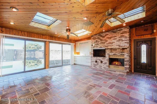 a view of an empty room with a fireplace and a window