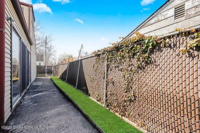 a view of a pathway of a building with wooden fence