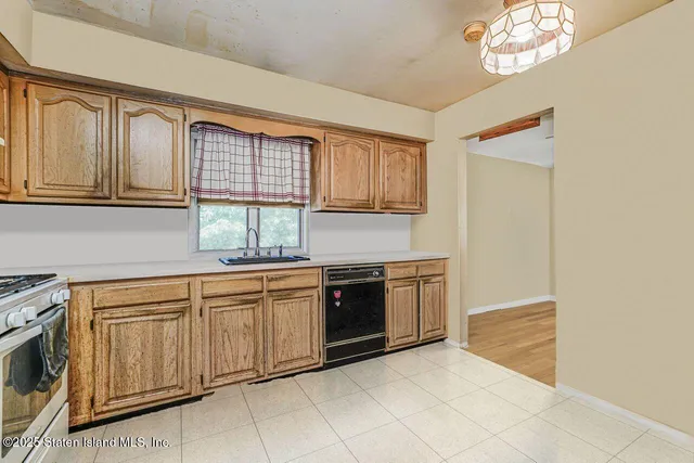 a kitchen with granite countertop white cabinets and window