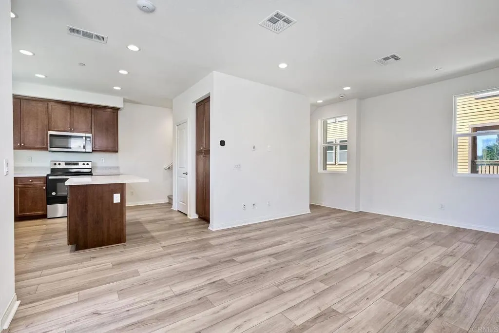 295 Mission Villas Road San Marcos, CA 92069 - Photo 8 of 29 a kitchen with stainless steel appliances granite countertop a refrigerator stove top oven and sink with wooden floor