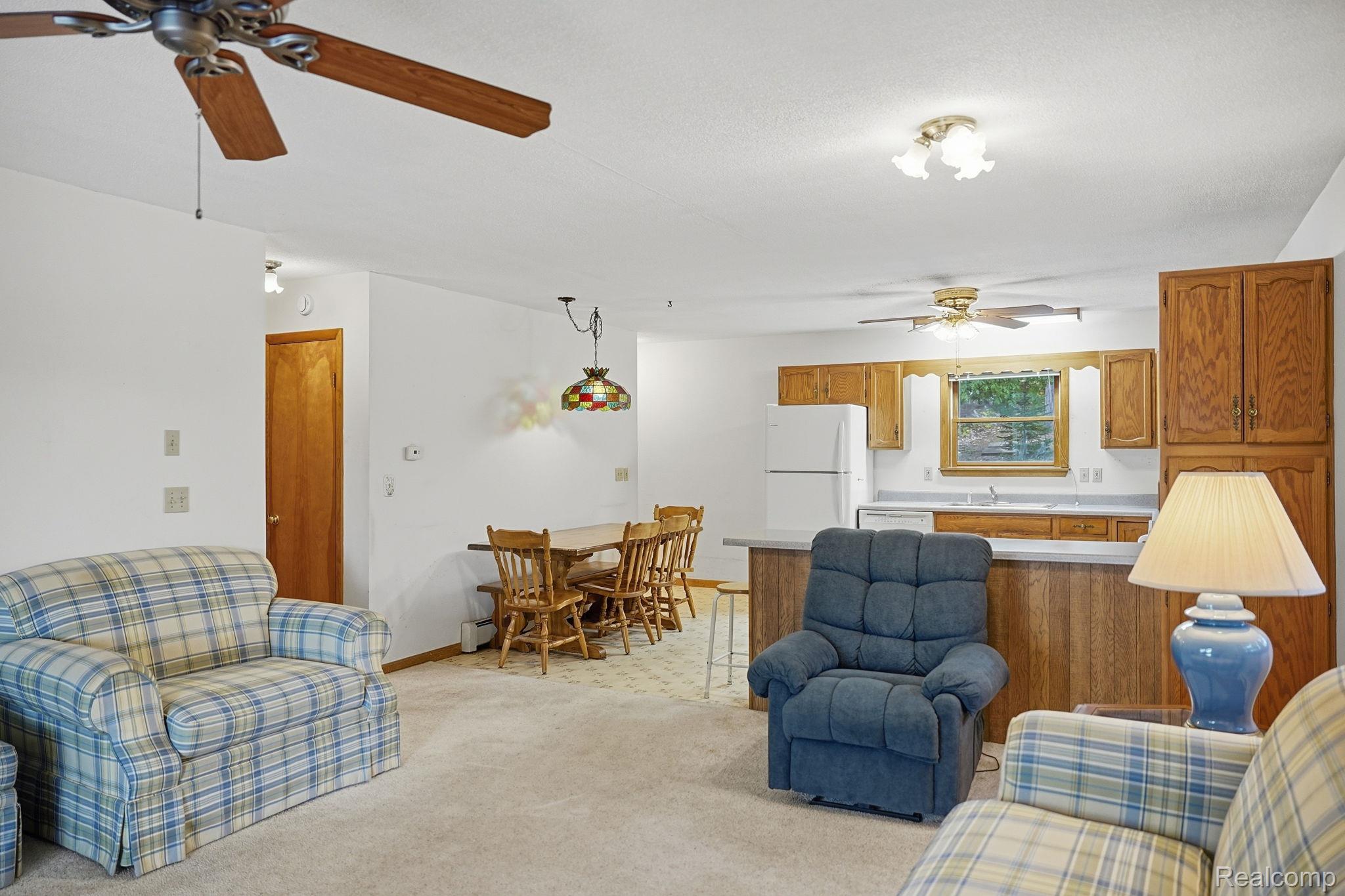 2259 Kassuba Road Gaylord, MI 49735 - Photo 9 of 46 Open concept living space featuring a ceiling fan, white walls, and light-toned carpeting