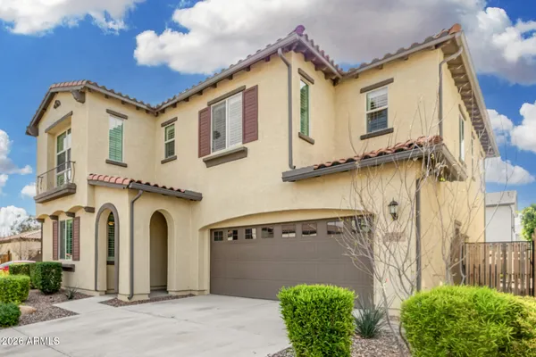 a view of a white house with a small yard and plants