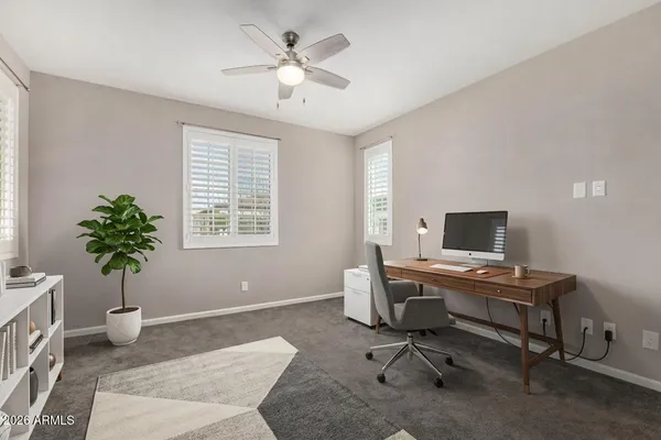 a view of a workspace with furniture and a window