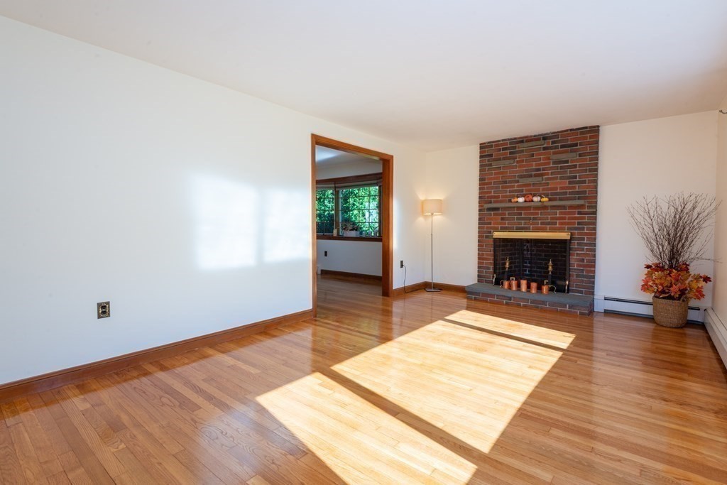 114 Spring Street Stoneham, MA 02180 - Photo 6 of 41 a view of a livingroom with wooden floor and a fireplace