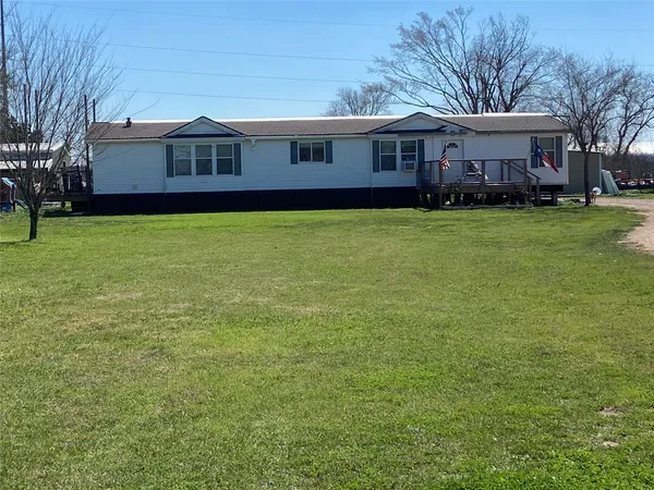a front view of a house with a garden and trees
