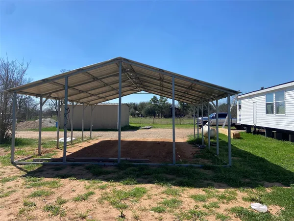 a view of a backyard with table and chairs under an umbrella