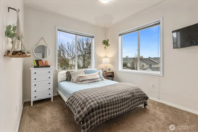 a bedroom with a bed and a flat tv screen on dresser