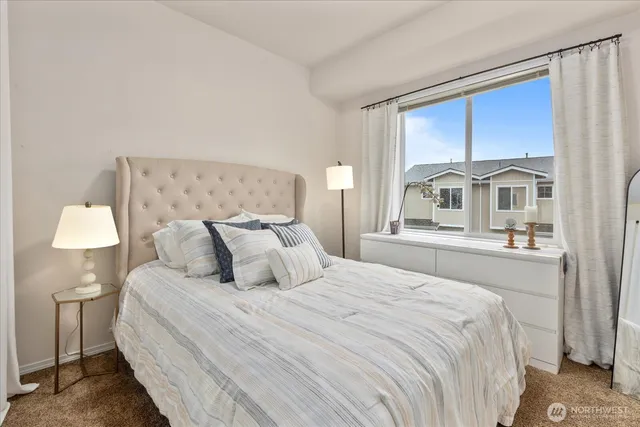 a bedroom with a large bed and a lamp