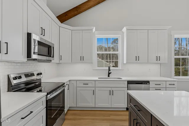 a kitchen with cabinets appliances a sink and a counter space