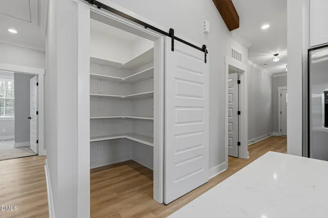a view of an empty room with a window and fireplace