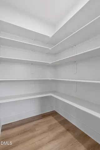 a large kitchen with stainless steel appliances kitchen island granite countertop a stove a sink dishwasher a microwave oven and a dining table with wooden floor